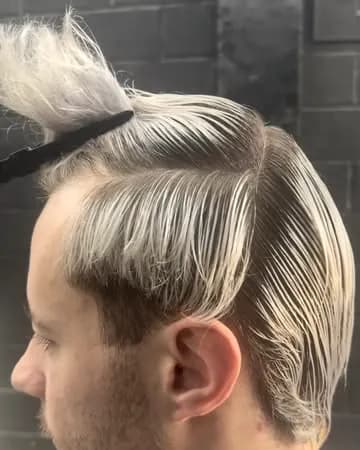 Cliente de perfil con el pelo decolorado peinado hacia atrás, sujeto con una pinza